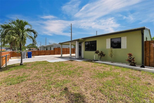 back of house with a yard and a patio area