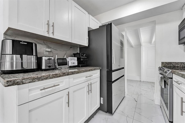 kitchen featuring white cabinets, stainless steel electric stove, and dark stone countertops