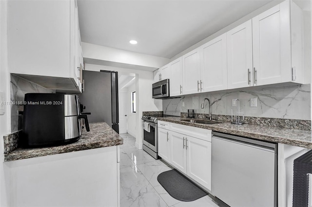 kitchen featuring decorative backsplash, sink, white cabinetry, and stainless steel appliances