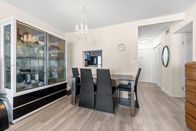 421 NE 14th Ave Unit 405, Hallandale Beach, FL 33009 - dining area with wood finished floors, a chandelier, a textured ceiling, and baseboards