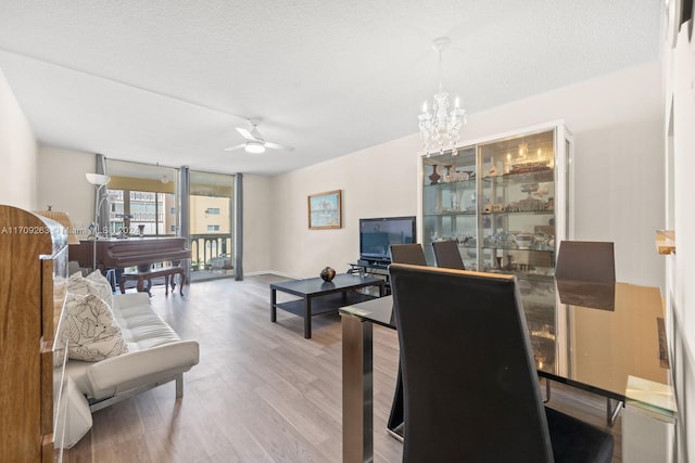 office with ceiling fan with notable chandelier, wood-type flooring, and a textured ceiling