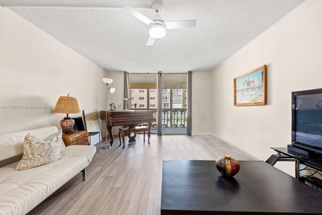 421 NE 14th Ave Unit 405, Hallandale Beach, FL 33009 - living room with light wood-style floors, a textured ceiling, and a ceiling fan