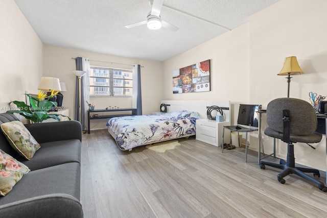 bedroom with a textured ceiling, light wood-type flooring, and ceiling fan