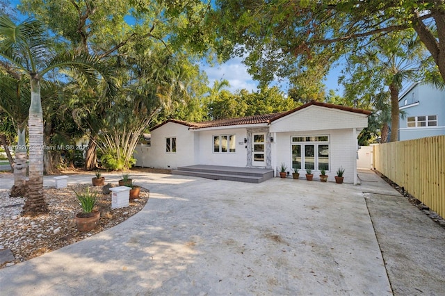 back of property featuring a patio area, a tiled roof, a deck, and fence