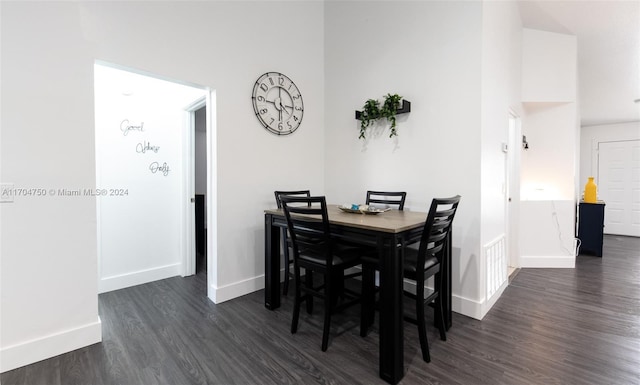 dining room featuring a high ceiling and dark wood-type flooring