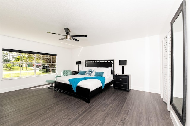 bedroom with a textured ceiling, dark hardwood / wood-style flooring, and ceiling fan