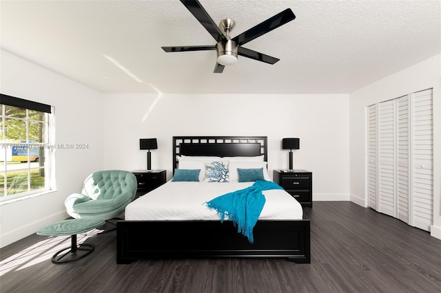 bedroom with ceiling fan, dark hardwood / wood-style floors, a textured ceiling, and a closet