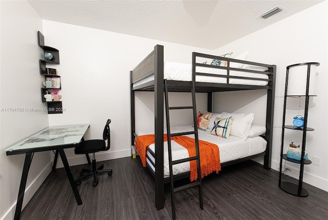 bedroom with a textured ceiling and dark wood-type flooring