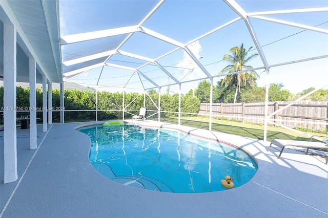 view of pool featuring a yard, a patio, and glass enclosure