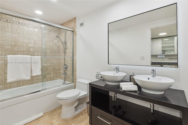 full bathroom featuring tile patterned floors, vanity, enclosed tub / shower combo, and toilet