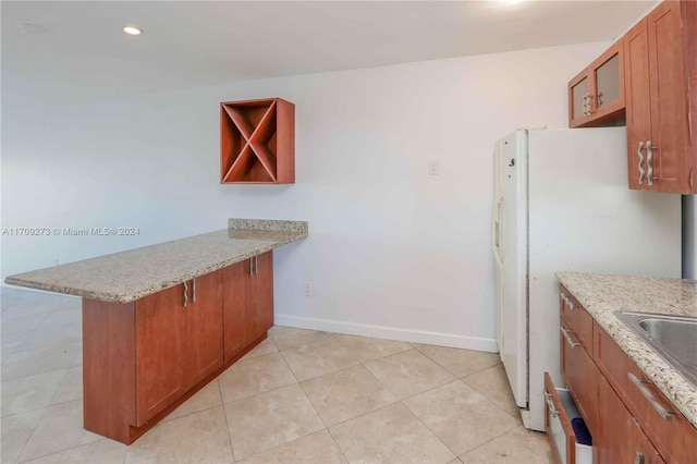 7410 SW 82nd St Unit K405, Miami, FL 33143 - kitchen featuring a peninsula, brown cabinetry, freestanding refrigerator, light stone countertops, and recessed lighting