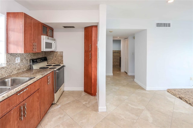 7410 SW 82nd St Unit K405, Miami, FL 33143 - kitchen with white appliances, tasteful backsplash, brown cabinets, glass insert cabinets, and light tile patterned floors