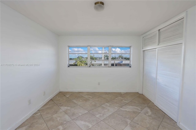 unfurnished bedroom featuring a closet and light tile patterned flooring