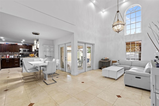 living room with light tile patterned flooring, a high ceiling, and french doors