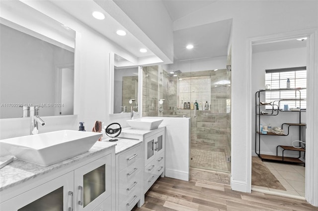 bathroom with hardwood / wood-style flooring, vanity, and an enclosed shower