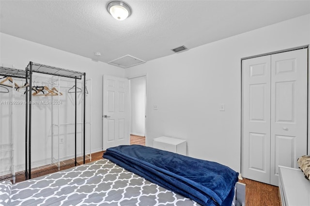 bedroom featuring hardwood / wood-style floors and a textured ceiling