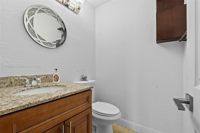 bathroom featuring tile patterned flooring, vanity, and toilet