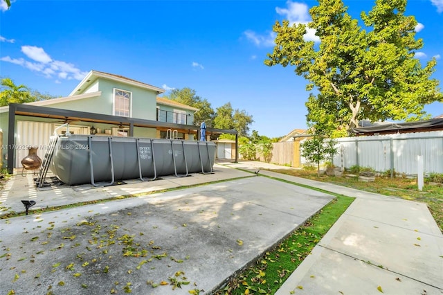 back of house featuring a patio and a fenced in pool