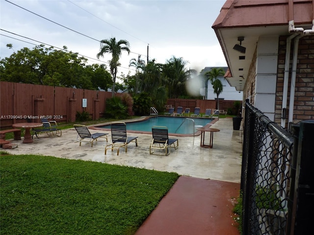 view of swimming pool with a patio area and a lawn