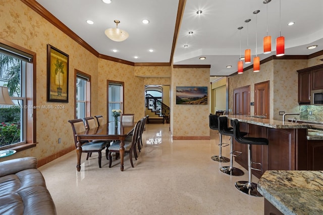 dining space featuring vaulted ceiling and crown molding