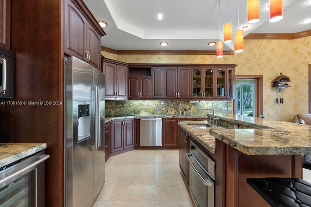 kitchen with dark brown cabinetry, sink, hanging light fixtures, and appliances with stainless steel finishes