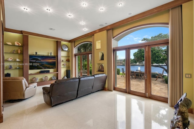 living room with french doors, built in shelves, and ornamental molding