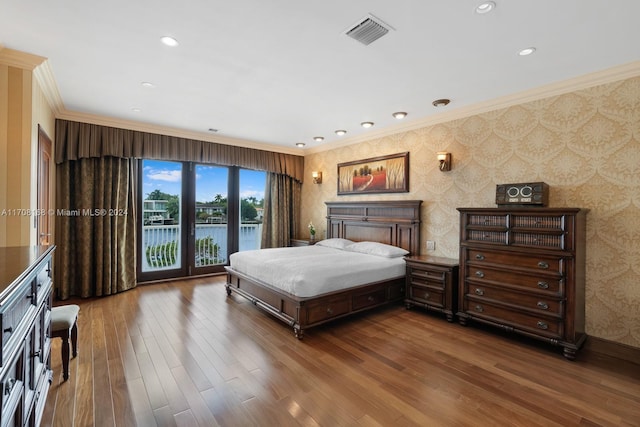 bedroom with access to exterior, dark hardwood / wood-style flooring, a water view, and ornamental molding