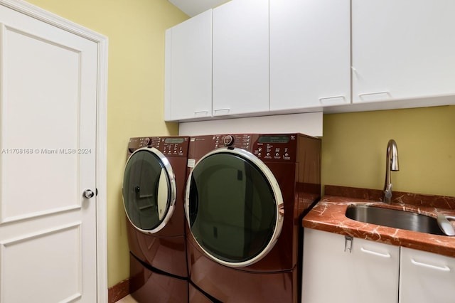 laundry room featuring cabinets, independent washer and dryer, and sink