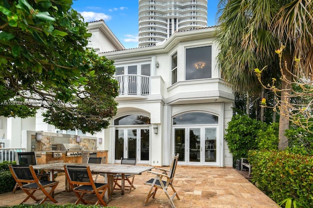 back of house featuring a patio area, french doors, and a balcony