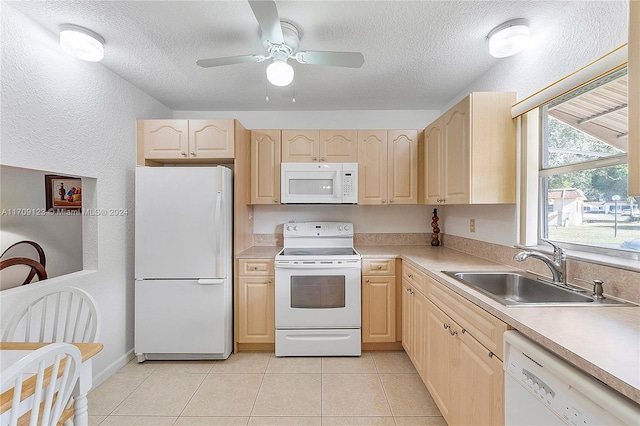 kitchen featuring light brown cabinets, white appliances, and sink