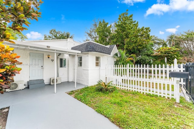 view of front of house with a front yard and ac unit