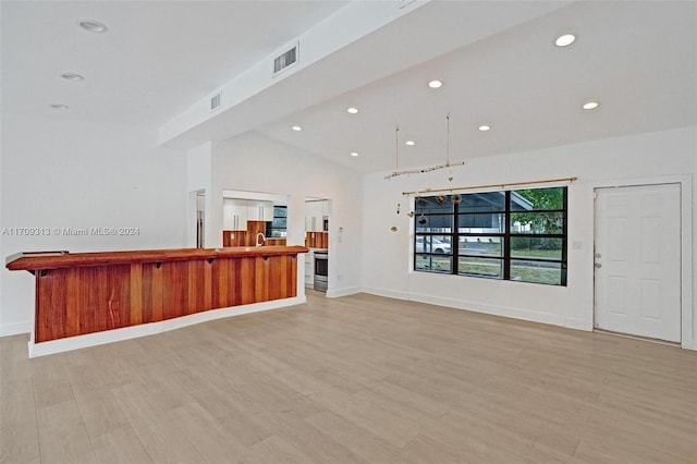 unfurnished living room with light hardwood / wood-style flooring and lofted ceiling