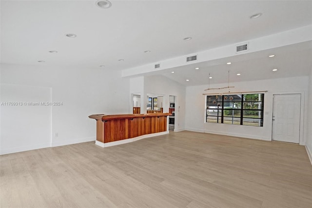 unfurnished living room with light hardwood / wood-style floors and vaulted ceiling