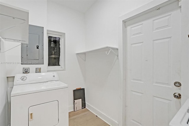 clothes washing area featuring washer / dryer, light wood-type flooring, and electric panel