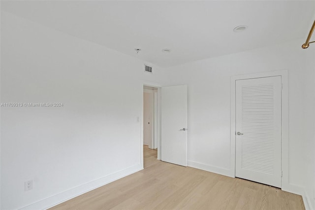 unfurnished bedroom with a closet and light wood-type flooring