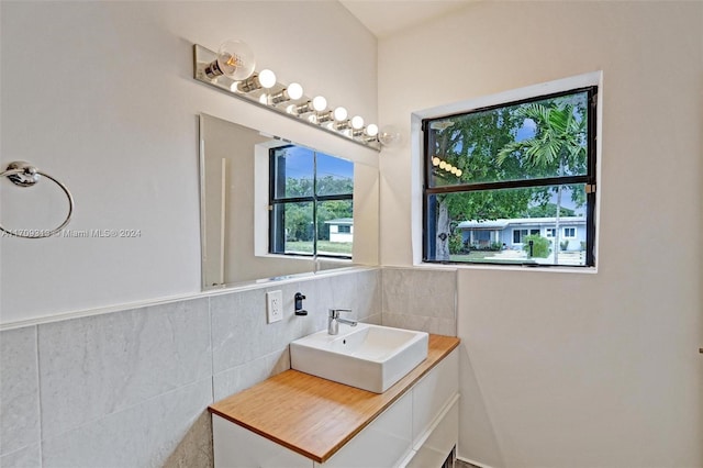 bathroom with vanity and tile walls