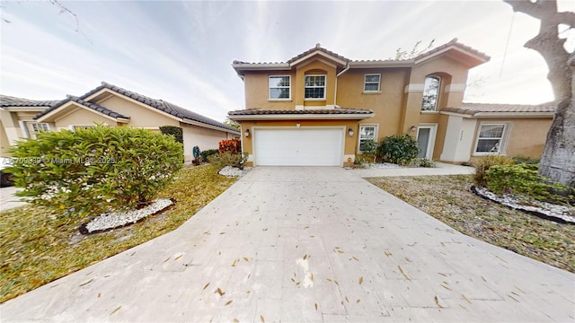 view of front of property featuring a garage, a tile roof, driveway, and stucco siding