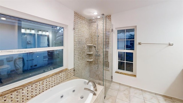 bathroom featuring a stall shower, tile patterned flooring, and a jetted tub