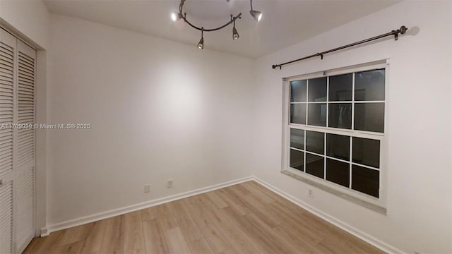 unfurnished room with light wood finished floors and baseboards