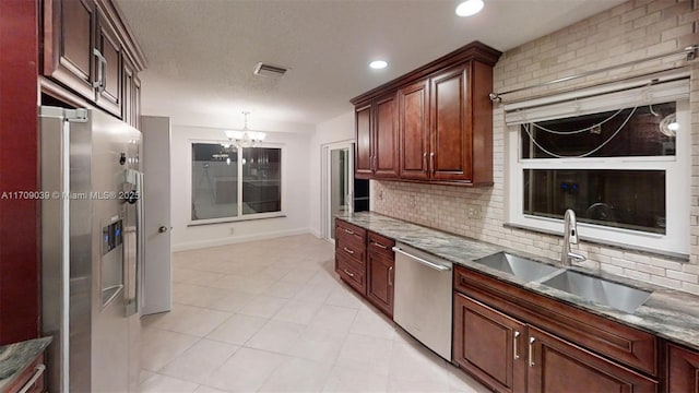 kitchen with stainless steel appliances, visible vents, a sink, and backsplash