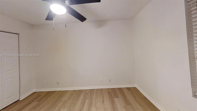 spare room featuring a ceiling fan, baseboards, and light wood finished floors