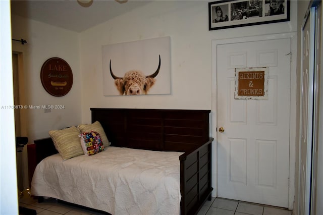 tiled bedroom featuring vaulted ceiling and ceiling fan