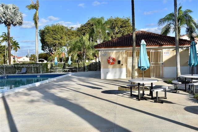 view of pool with an outbuilding and a patio