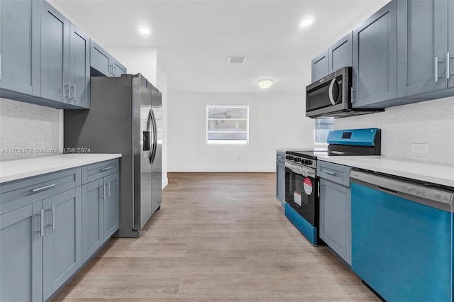 kitchen with tasteful backsplash, light hardwood / wood-style flooring, and stainless steel appliances