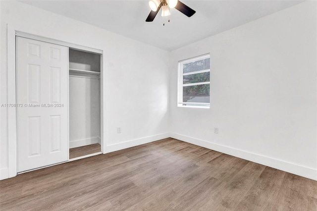 unfurnished bedroom featuring ceiling fan, a closet, and hardwood / wood-style flooring