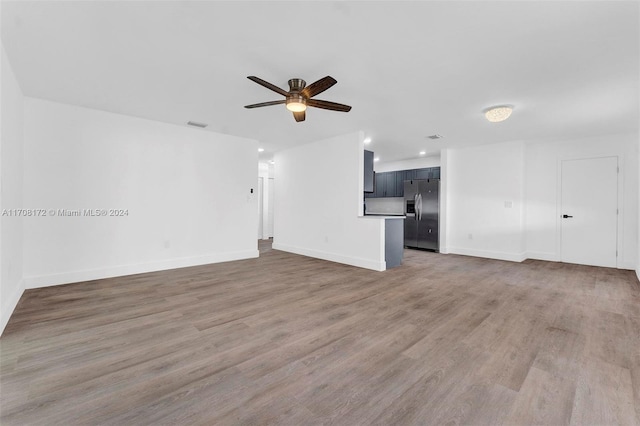 unfurnished living room with dark hardwood / wood-style floors and ceiling fan