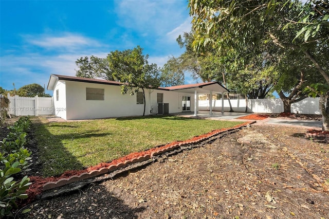 back of property with central air condition unit, a patio area, and a lawn