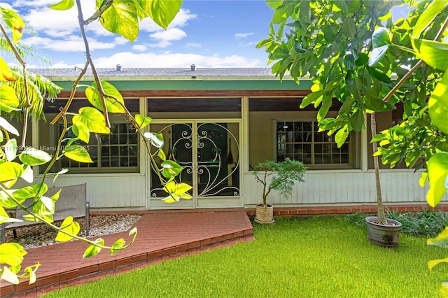 doorway to property with a lawn