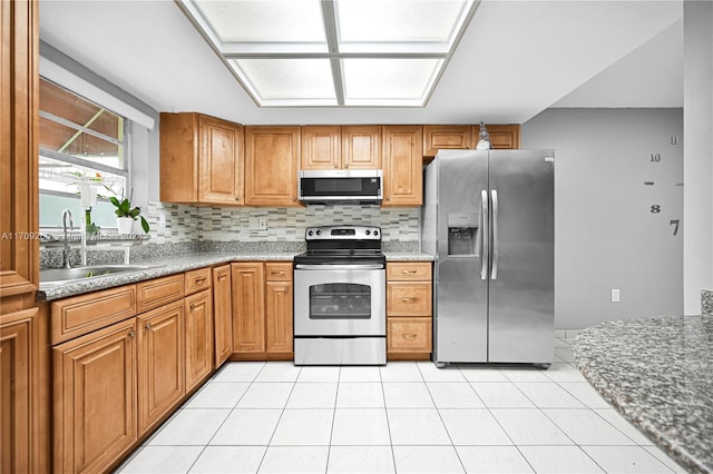 kitchen featuring light tile patterned flooring, sink, stainless steel appliances, and tasteful backsplash