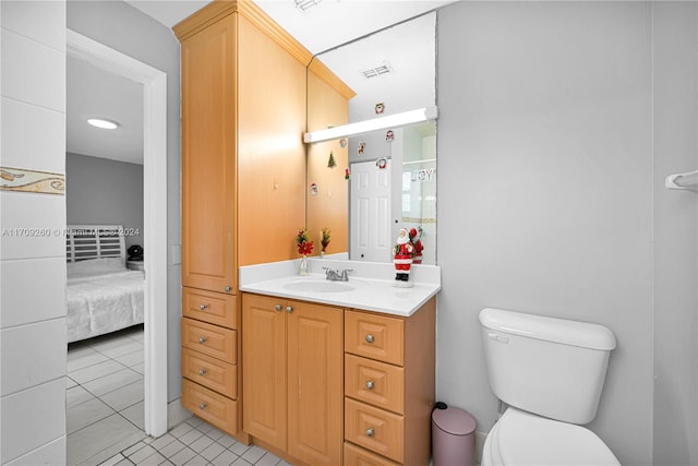 bathroom with tile patterned flooring, vanity, and toilet